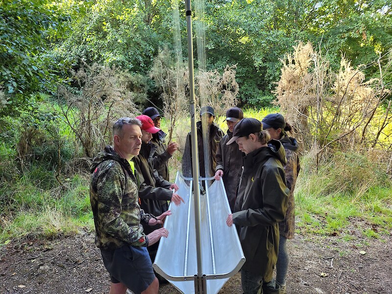 Ian explaining how to set up the Harp traps. The tauira helping to put these together and place them.