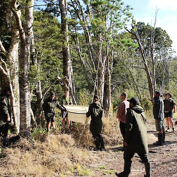 Ian explaining how to set up the Harp traps. The tauira helping to put these together and place them.