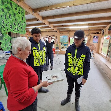 Chris Rance showing tauira the process of drying seeds.