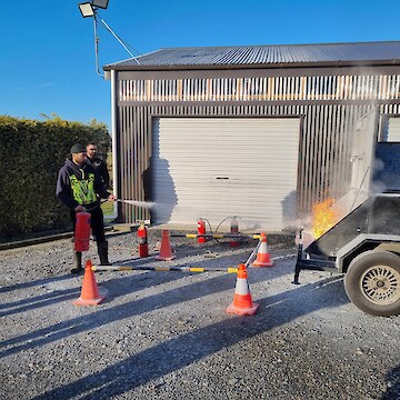 Raniera Smyth using the foam extinguisher to put out the fire.