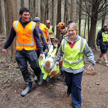 Josh Aitken being carried in a stretcher created by the tauira and crew.